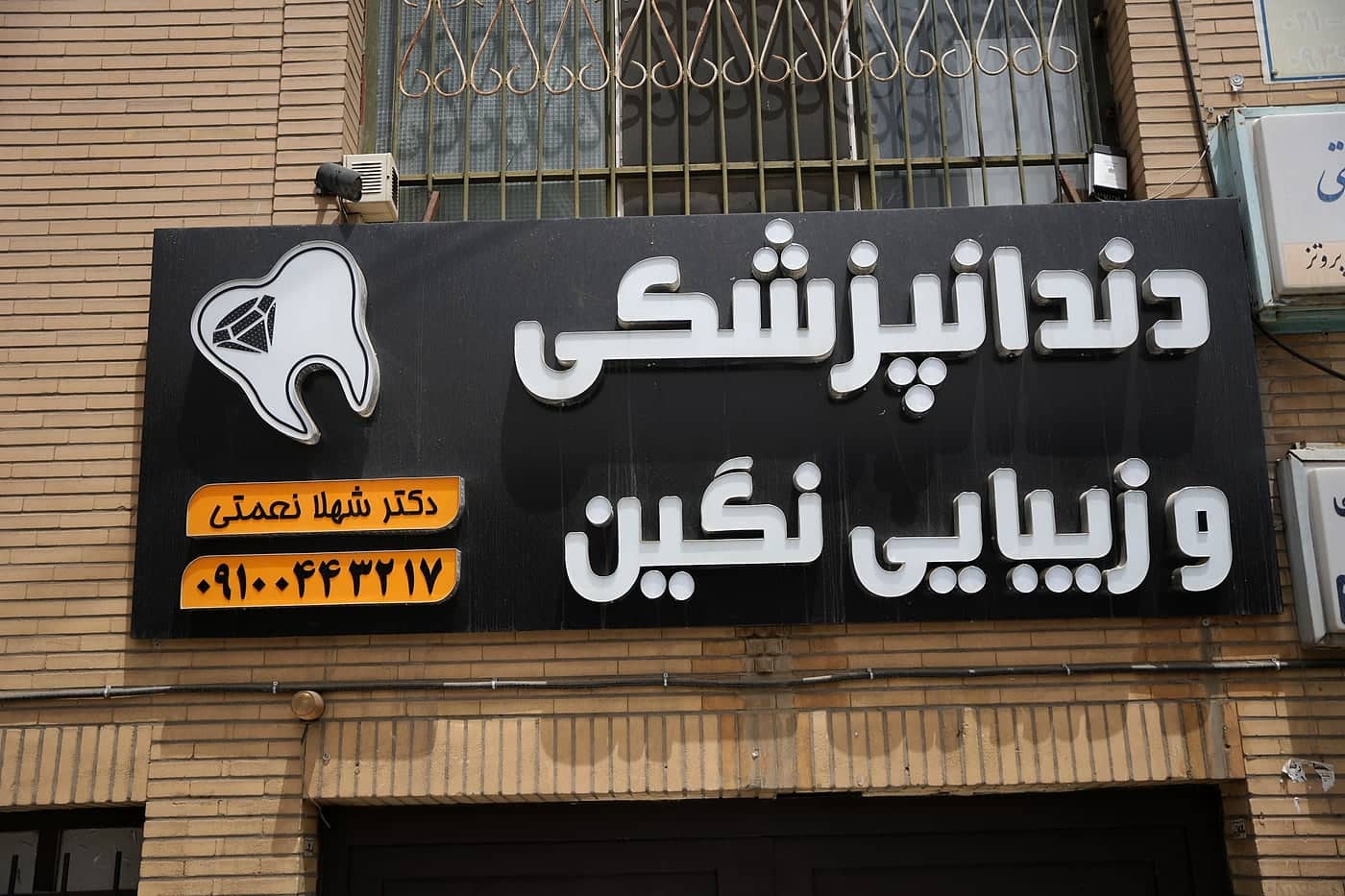 تابلوی «دندانپزشکی و زیبایی نگین» با نام دکتر شهلا نعمتی روی ساختمان