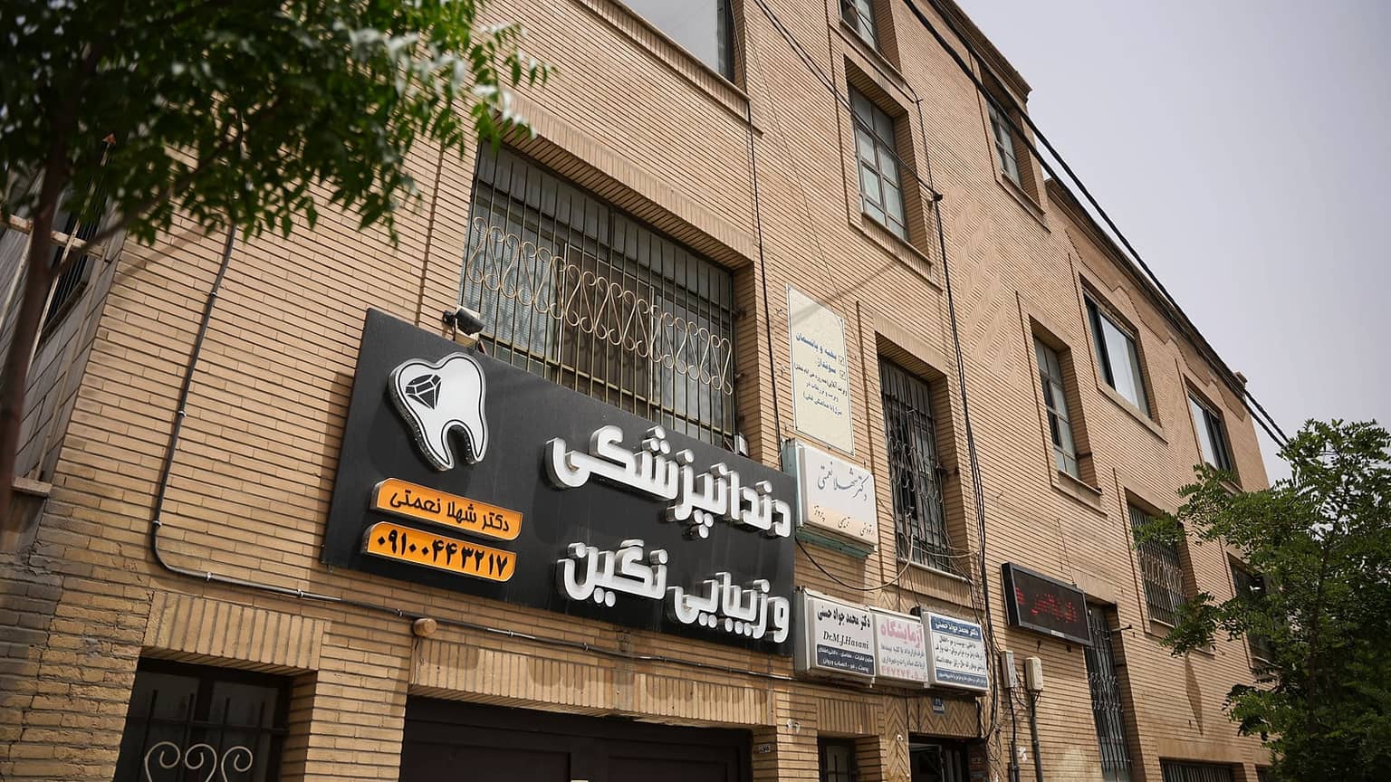 ساختمان کلینیک نگین از زاویهٔ خیابان؛ تابلوی دندانپزشکی و زیبایی نگین